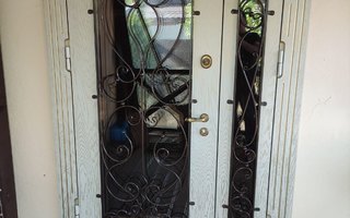 стальная двустворчатая дверь в загородный дом с ковкой и двумя стеклопакетам